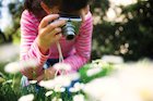 Girl taking photo of flower