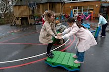 Children in winter coats playing in school playground