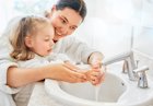 child washing hands with adult