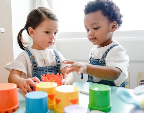 Young boy and girl playing together with plastic cups Young boy and girl playing together with plastic cups