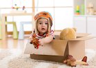 A baby boy playing in a cardboard box
