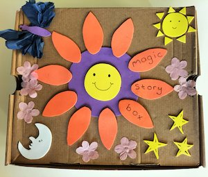A cardboard box decorated with felt shapes with the words 'Magic Story Box' A cardboard box decorated with felt shapes with the words 'Magic Story Box'
