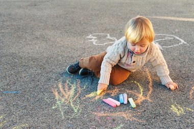 Boy drawing on a playground with chalk Boy drawing on a playground with chalk