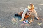 Boy drawing on a playground with chalk 