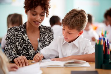 Teacher helping child with school work Teacher helping child with school work