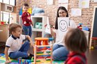 Teacher with group of boys sitting on table talking about emotions