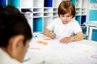 child in classroom doing an art project
