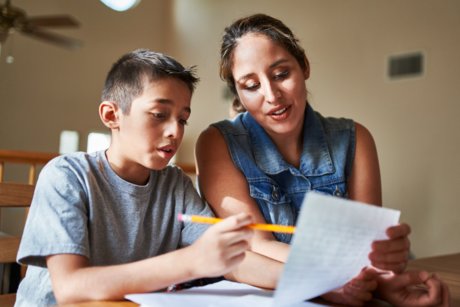 Woman helping child with schoolwork