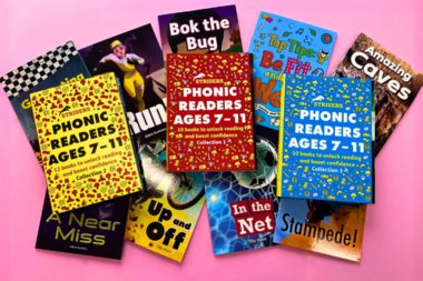 A selection of Striders Phonics Readers on a plain pink background