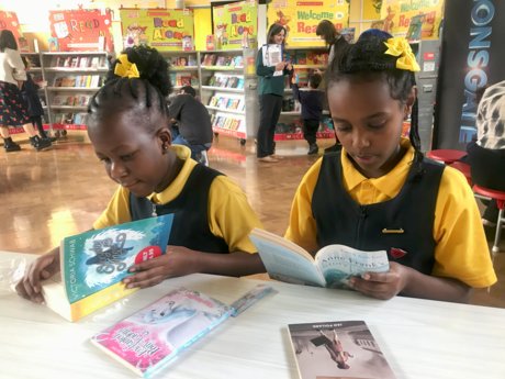 Two little girls reading books together. Two little girls reading books together.