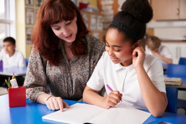 A teacher helping a student revise in the classroom.